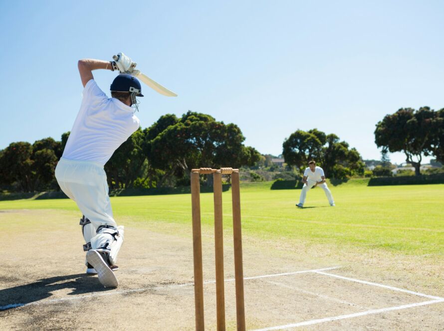 Rear view of player batting while playing cricket on field